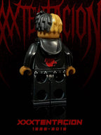 XXXTENTACION custom minifigure with half-black, half-yellow braids, "BAD" hoodie, black jeans, dark aesthetic packaging.