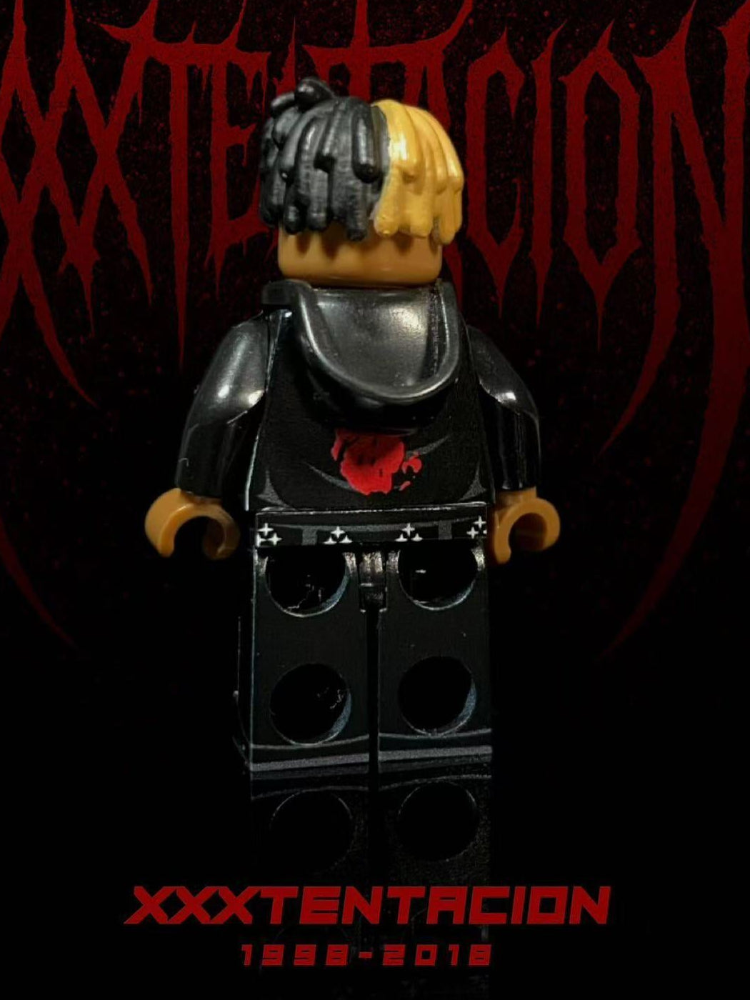 XXXTENTACION custom minifigure with half-black, half-yellow braids, "BAD" hoodie, black jeans, dark aesthetic packaging.