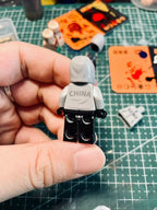 Kanye West "Vultures Shanghai 2025" custom minifigure in white hoodie and black cargo trousers, rear view.
